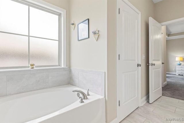 bathroom featuring baseboards and a bath