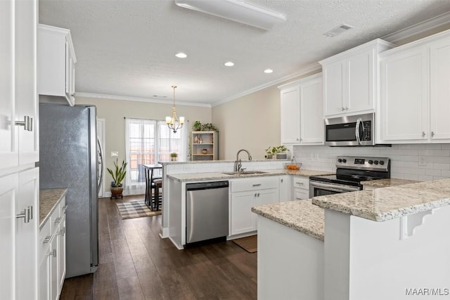 kitchen with visible vents, a peninsula, a sink, decorative backsplash, and stainless steel appliances