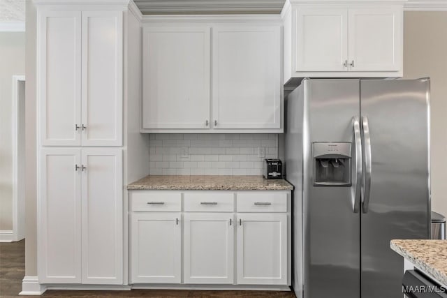 kitchen with light stone counters, wood finished floors, stainless steel fridge with ice dispenser, decorative backsplash, and white cabinets