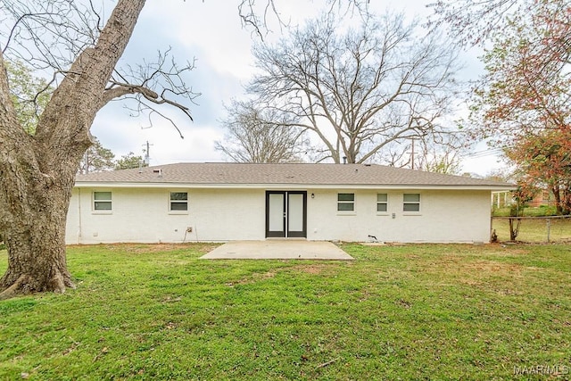rear view of house featuring a patio area, a yard, and fence