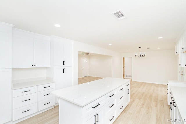 kitchen with visible vents, light wood-style floors, and white cabinets
