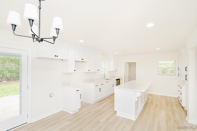 kitchen featuring a sink, a chandelier, light wood-style flooring, and a center island