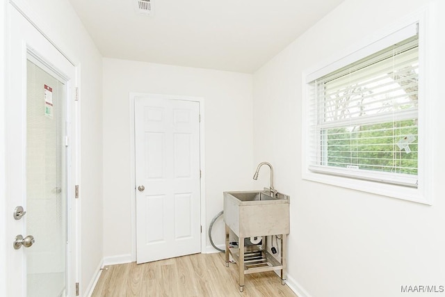 laundry room featuring visible vents, light wood-type flooring, and baseboards