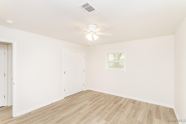 spare room with visible vents, baseboards, light wood-type flooring, and a ceiling fan
