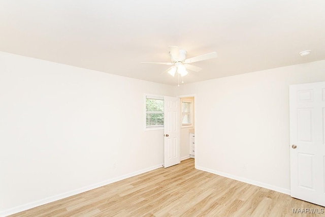 unfurnished room featuring baseboards, light wood-type flooring, and ceiling fan