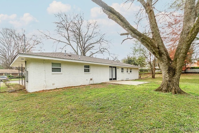 rear view of property with fence, a yard, a patio area, and brick siding