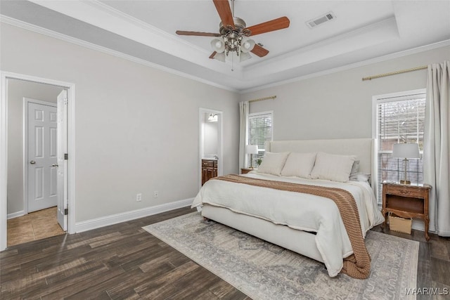 bedroom with a tray ceiling, visible vents, and dark wood finished floors