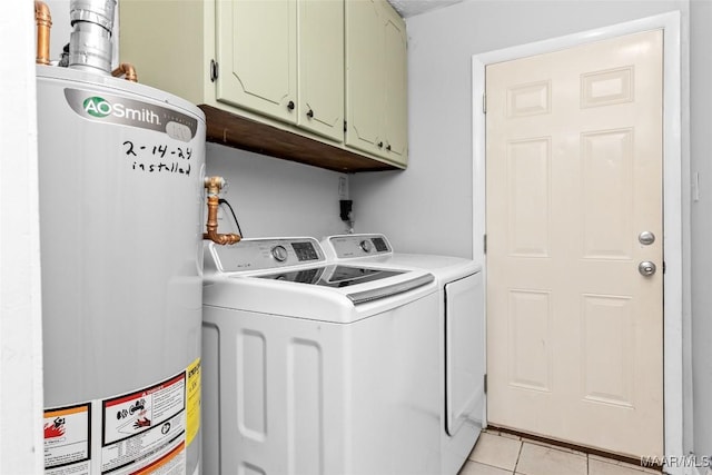 washroom with light tile patterned floors, cabinet space, separate washer and dryer, and water heater