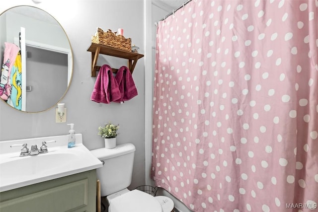 bathroom with curtained shower, toilet, and vanity