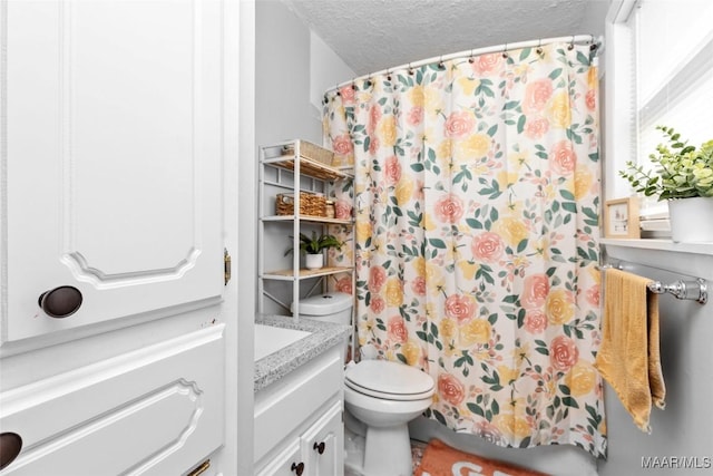 full bathroom with vanity, a shower with shower curtain, toilet, and a textured ceiling