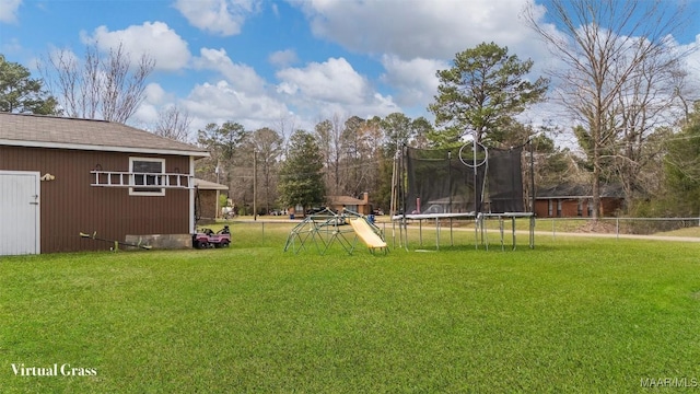 view of yard with a trampoline and fence