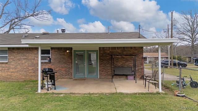 back of property with a patio, fence, brick siding, and a lawn