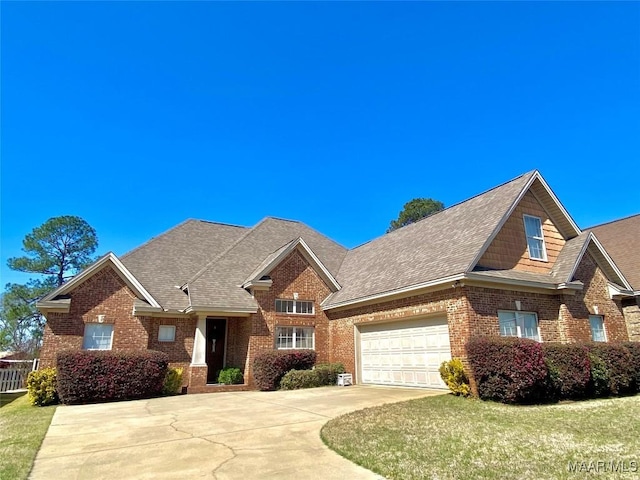 craftsman inspired home featuring brick siding, a shingled roof, fence, a garage, and driveway