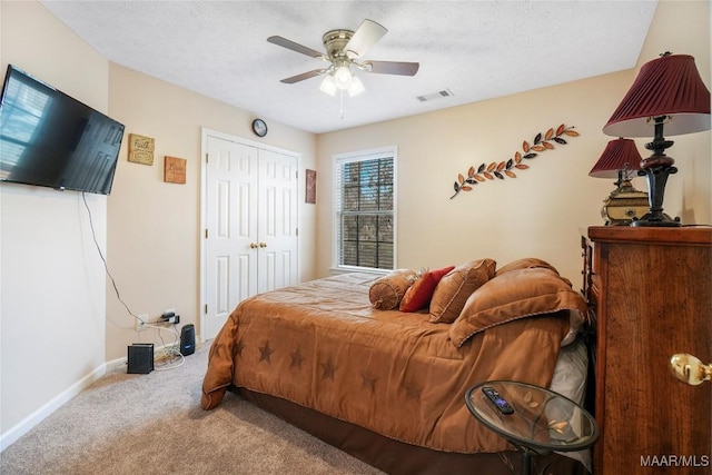 bedroom featuring visible vents, carpet flooring, a textured ceiling, and baseboards