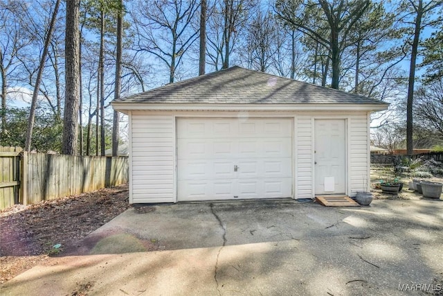 detached garage with fence and driveway