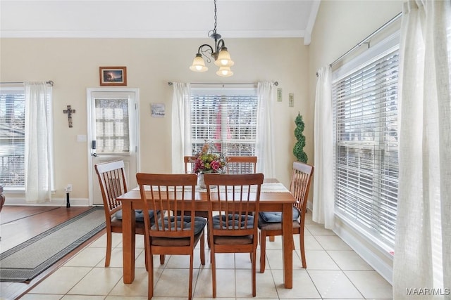 dining space with light tile patterned floors, a notable chandelier, baseboards, and ornamental molding