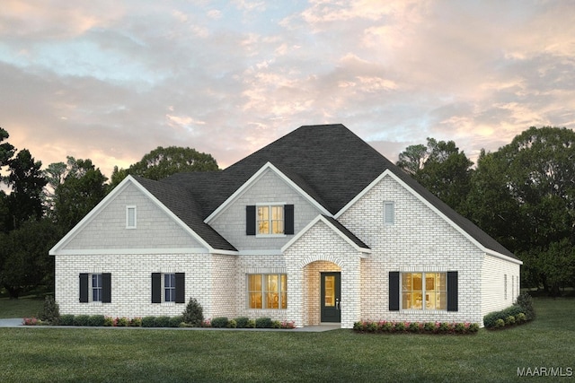 view of front of house featuring a lawn and brick siding