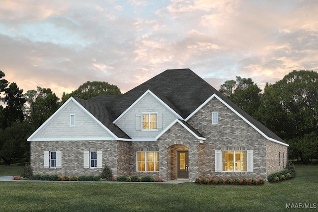 craftsman-style house featuring a yard and brick siding