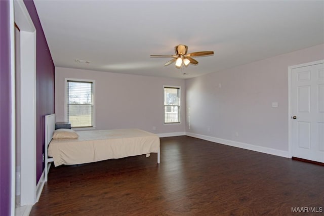 25882 Troy Hwy, Grady, AL 36036 - unfurnished bedroom featuring multiple windows, dark wood-style floors, visible vents, and baseboards