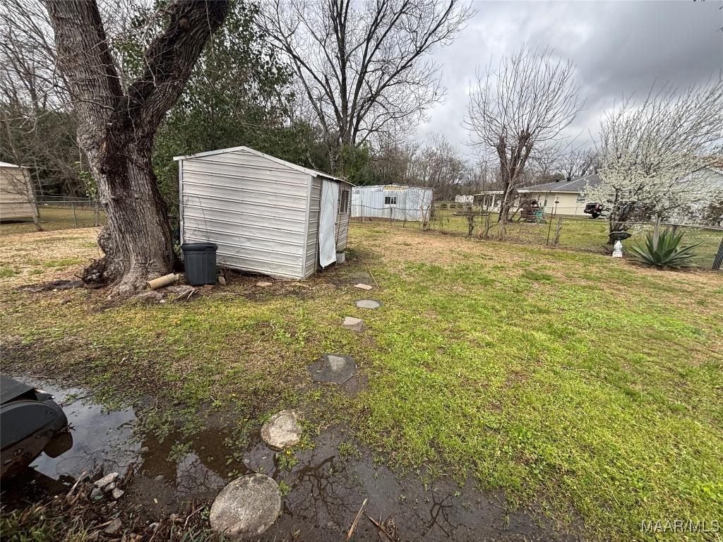 115 Kingswood Rd, Montgomery, AL 36108 - view of yard with an outdoor structure, fence, and a storage unit