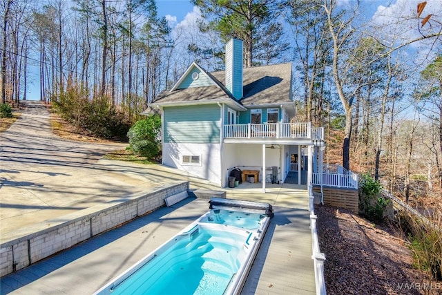 74 Lake Point Dr, Jacksons Gap, AL 36861 - back of house with a chimney, a balcony, and hot tub deck surround