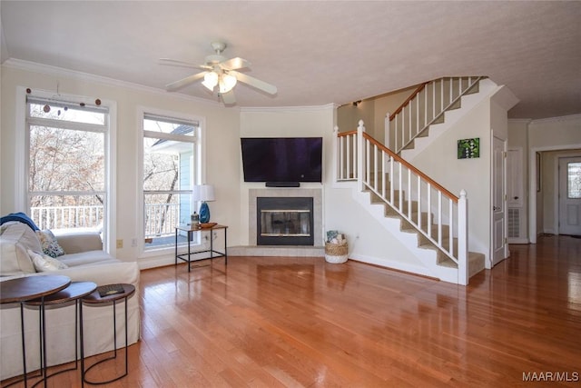 74 Lake Point Dr, Jacksons Gap, AL 36861 - living area featuring wood finished floors, stairway, a fireplace, crown molding, and ceiling fan