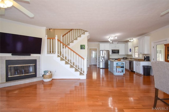 74 Lake Point Dr, Jacksons Gap, AL 36861 - living area with stairway, a tiled fireplace, crown molding, and light wood finished floors