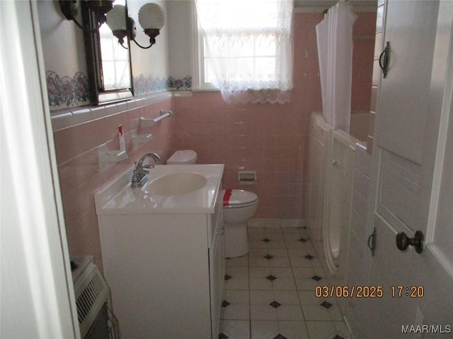 full bathroom with tile walls, toilet, a shower with shower curtain, tile patterned floors, and vanity