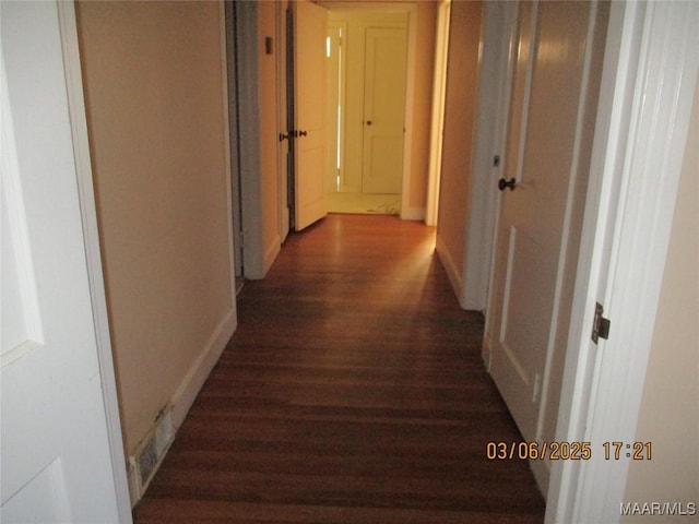 hall featuring baseboards and wood finished floors