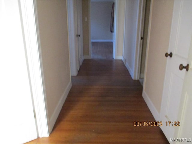 corridor with baseboards and light wood-style flooring