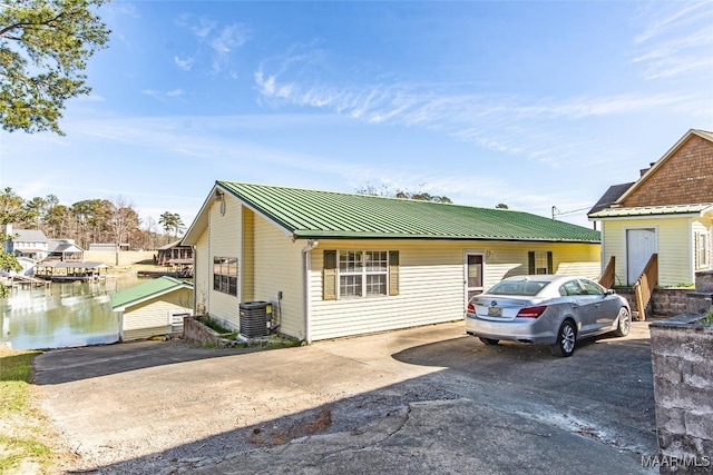 100 Royal Dr, Equality, AL 36026 - view of front of home with metal roof, a water view, central AC unit, and driveway