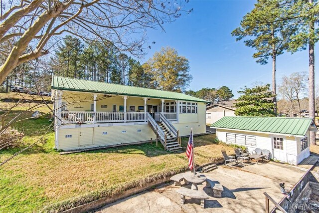 100 Royal Dr, Equality, AL 36026 - view of front of property featuring a front lawn, stairway, an outbuilding, and metal roof