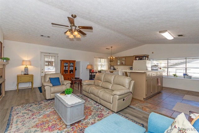 100 Royal Dr, Equality, AL 36026 - living room featuring visible vents, ceiling fan with notable chandelier, a textured ceiling, and vaulted ceiling