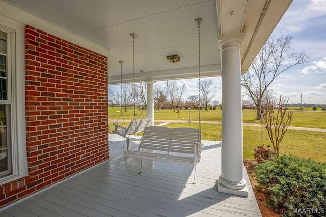 wooden deck with a porch and a lawn