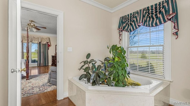 hall with a textured ceiling, crown molding, and wood finished floors
