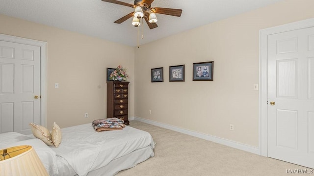 bedroom with light colored carpet, baseboards, and ceiling fan