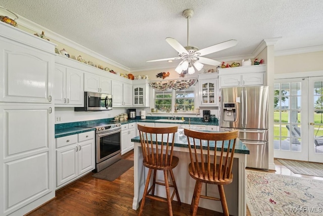 13650 County Road 29th Rd, Clanton, AL 35045 - kitchen featuring stainless steel appliances, dark countertops, white cabinets, a textured ceiling, and glass insert cabinets