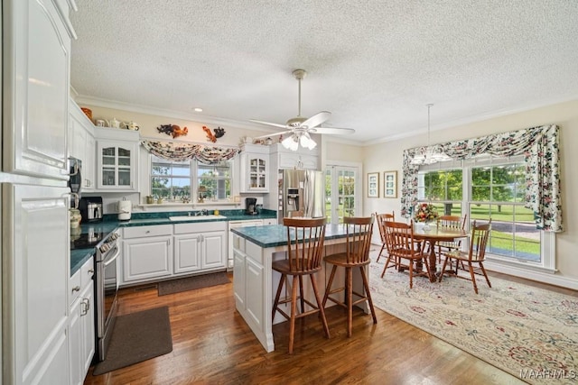 13650 County Road 29th Rd, Clanton, AL 35045 - kitchen with appliances with stainless steel finishes, a textured ceiling, crown molding, dark countertops, and white cabinetry