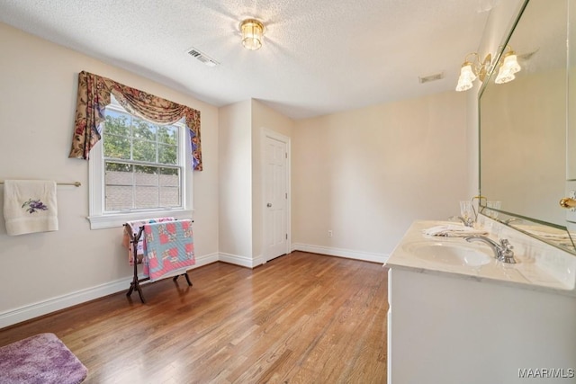 13650 County Road 29th Rd, Clanton, AL 35045 - full bath featuring wood finished floors, double vanity, and a textured ceiling
