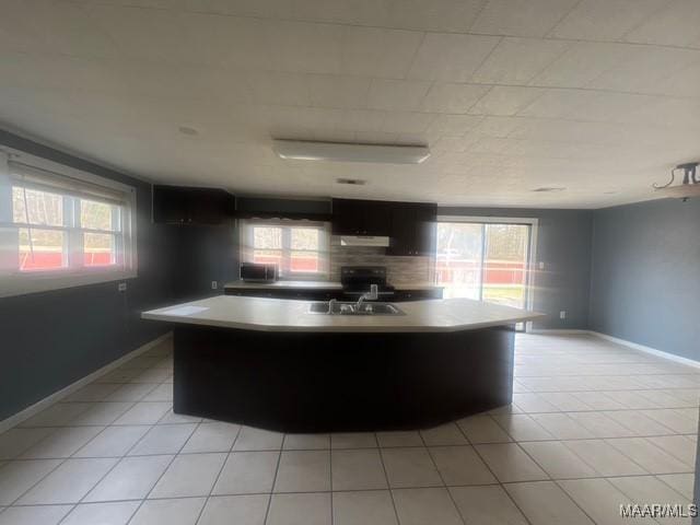 2343 Friendship Rd, Tallassee, AL 36078 - kitchen featuring under cabinet range hood, light tile patterned floors, and a wealth of natural light