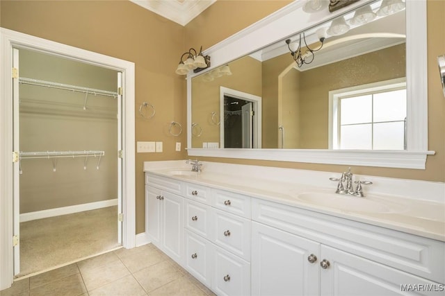 1605 Guiding Way Ln, Prattville, AL 36067 - bathroom featuring crown molding, double vanity, tile patterned floors, a walk in closet, and baseboards