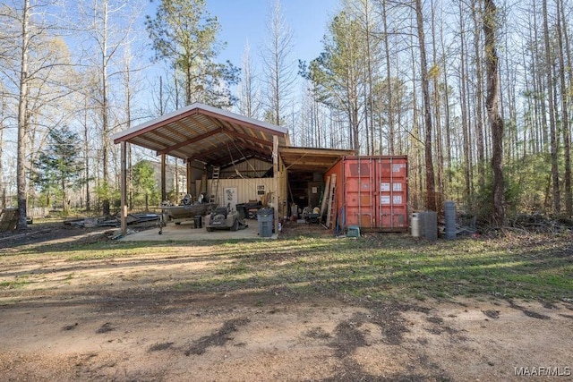 view of pole building with dirt driveway