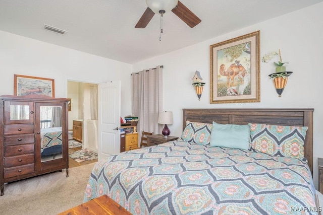 carpeted bedroom with visible vents, ceiling fan, and vaulted ceiling