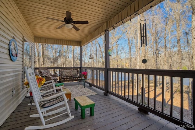 wooden deck featuring an outdoor hangout area and a ceiling fan