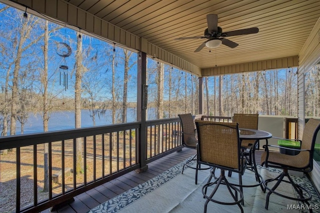 deck featuring outdoor dining space, a water view, and ceiling fan