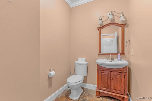 bathroom featuring toilet, stone finish flooring, crown molding, baseboards, and vanity
