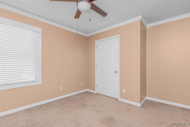 unfurnished room featuring crown molding, a ceiling fan, baseboards, and light carpet