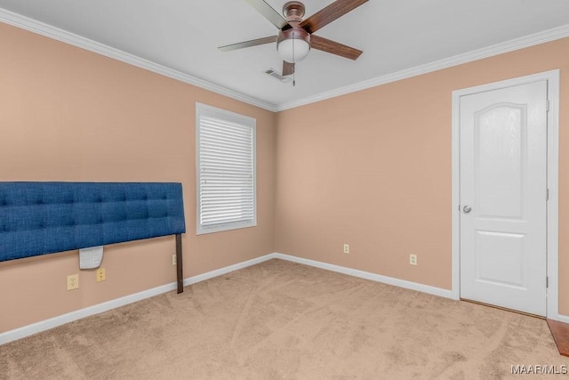 empty room with visible vents, carpet, ceiling fan, and ornamental molding