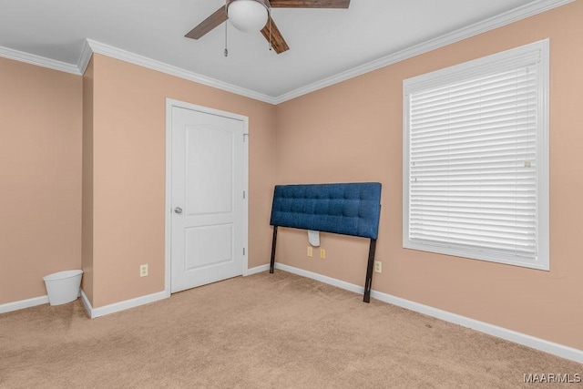 unfurnished room featuring baseboards, carpet, crown molding, and a ceiling fan
