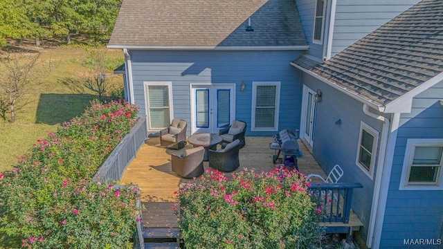 back of house featuring a wooden deck and a shingled roof